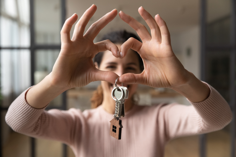 woman forming heart shape with key