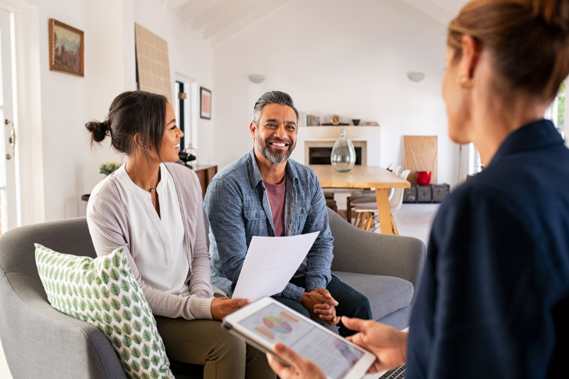 couple talking to real estate agent woman