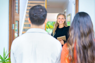 Real estate agent showing a young couple a new house. The house is modern and contemporary.